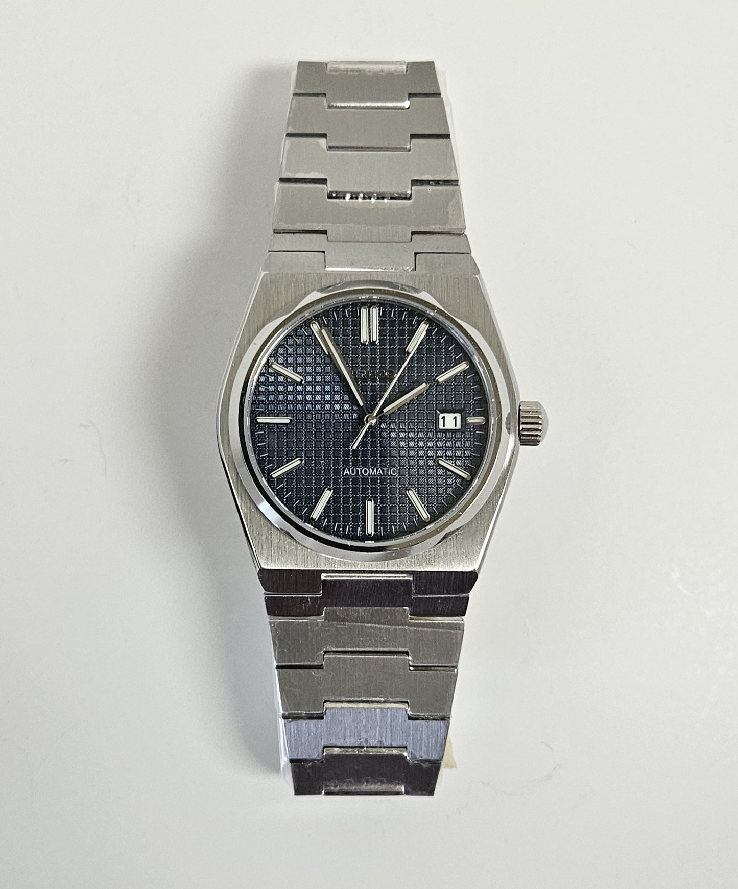 Stainless steel wristwatch with dark face on white background