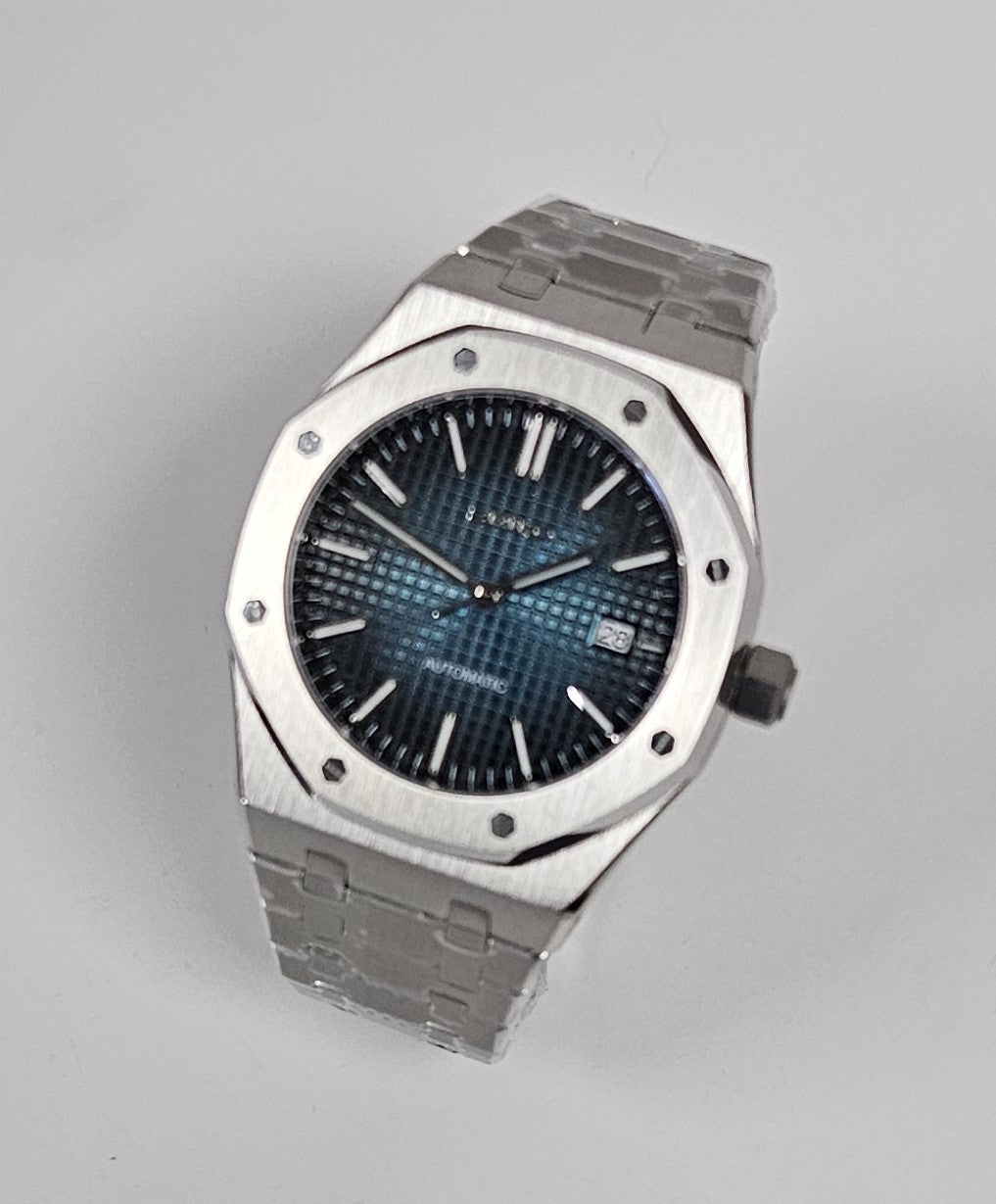 Luxury watch with blue face and silver case on white background
