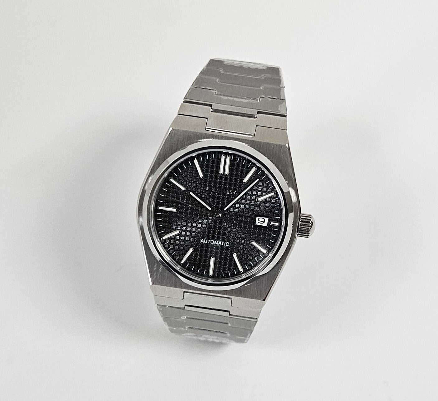 Stainless steel wristwatch with black dial on white background