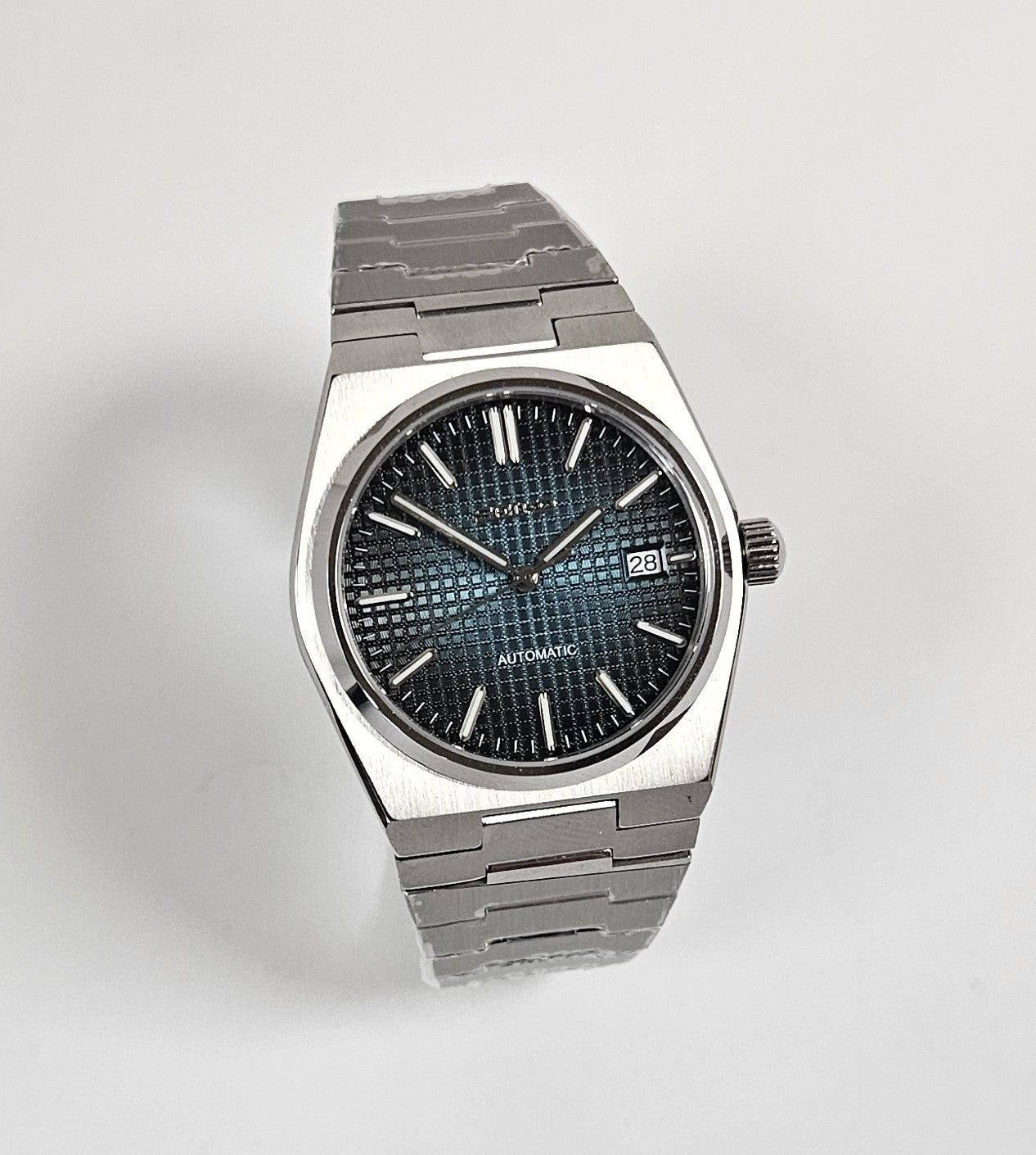 Silver wristwatch with a dark face on a light background