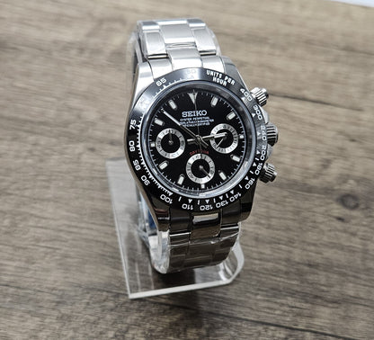 Seiko watch on a clear stand with a wooden background