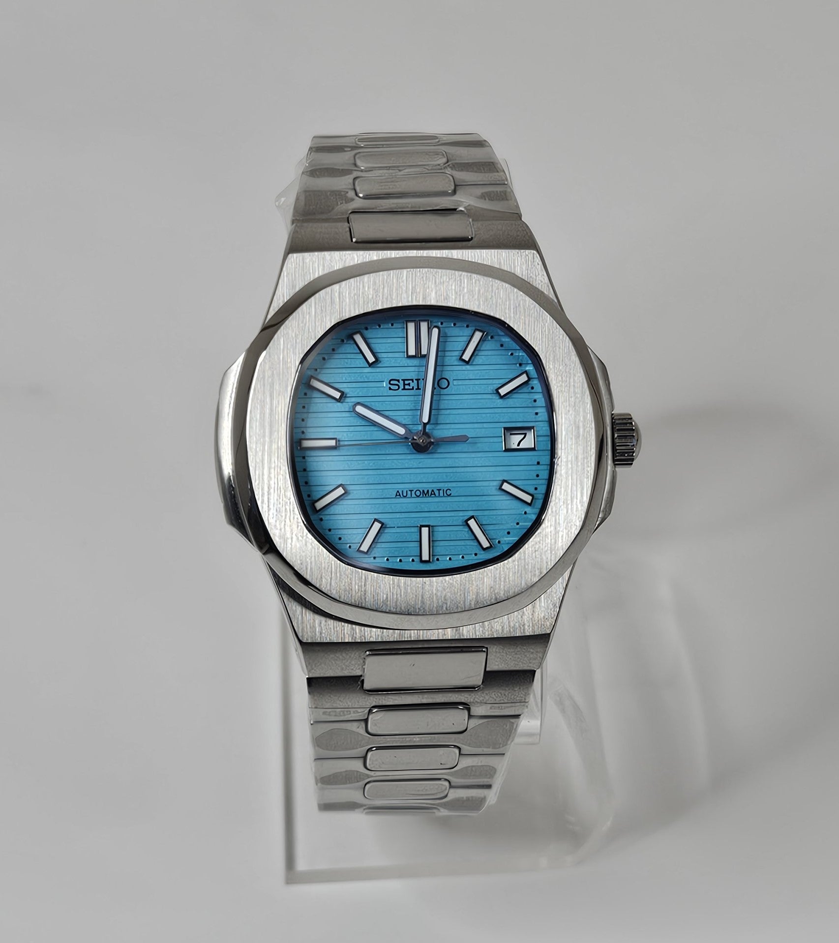 Silver watch with a blue face on a light gray background