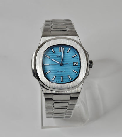 Silver watch with a blue face on a light gray background