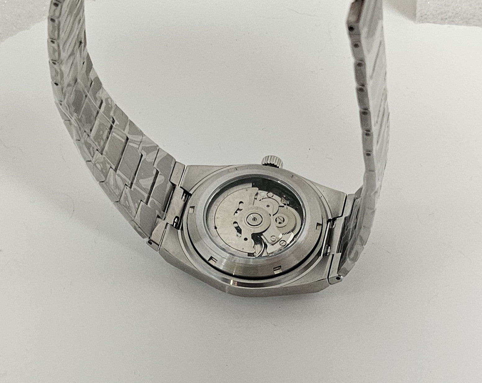 Watch back cover with metal band on white background