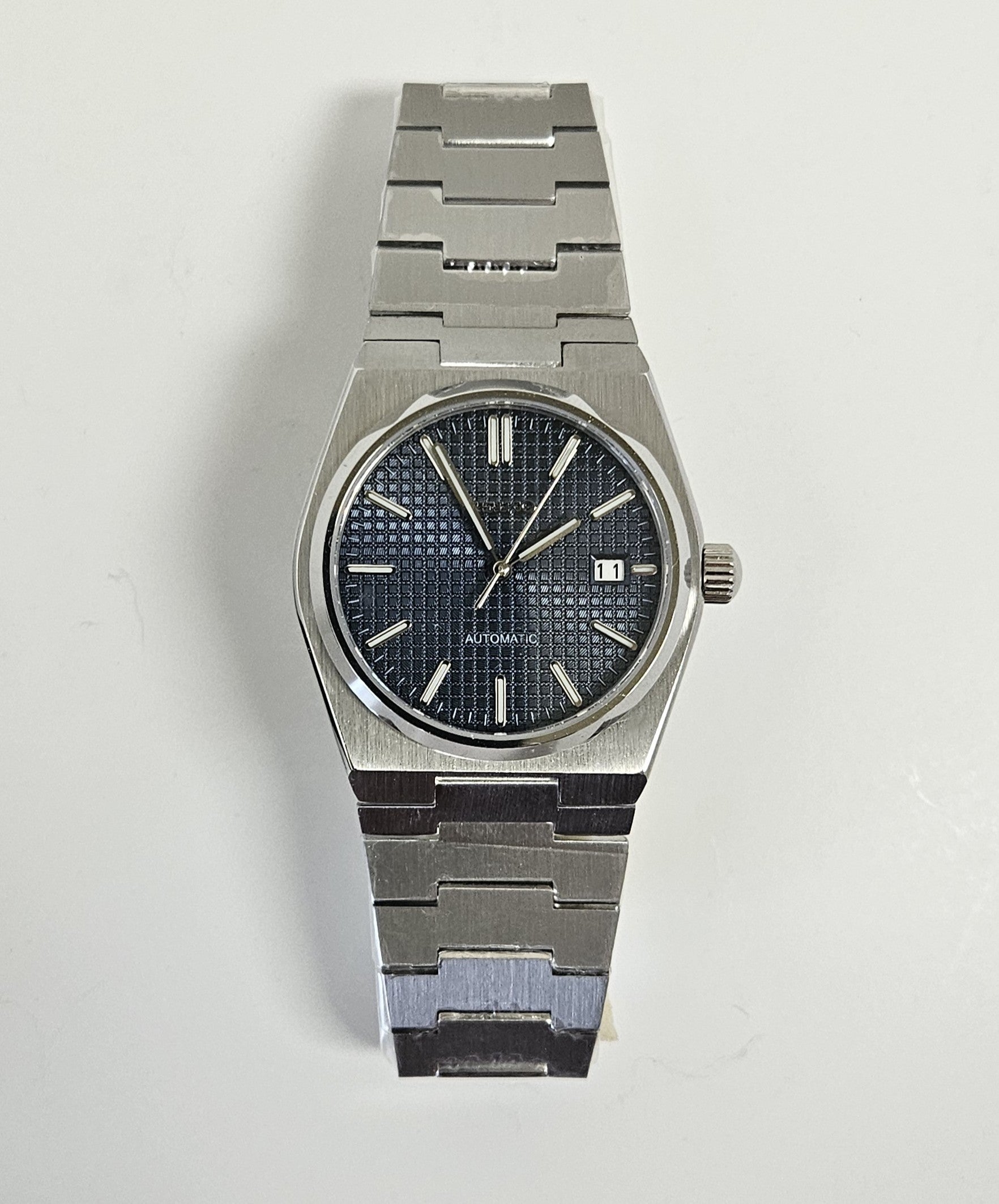 Stainless steel wristwatch with dark face on white background