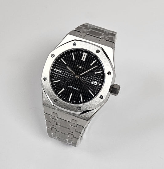 A black dial Royal Oak Seiko Mod watch with a stainless steel bracelet and a screw down case back.