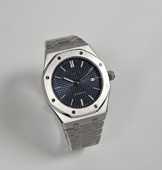A black dial Royal Oak Seiko Mod watch with a stainless steel bracelet and a screw down case back.