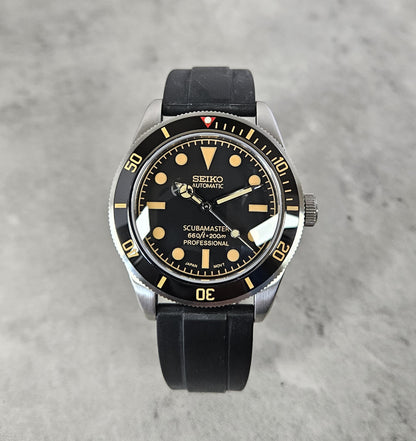 Seiko watch with black strap on a gray background