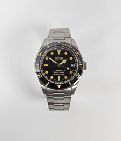 Seiko watch with black dial and silver metal strap on a white background