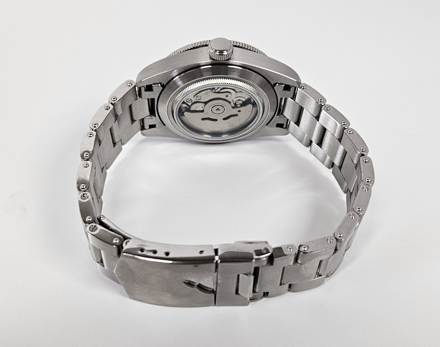 Silver watch with a metallic band on a white background
