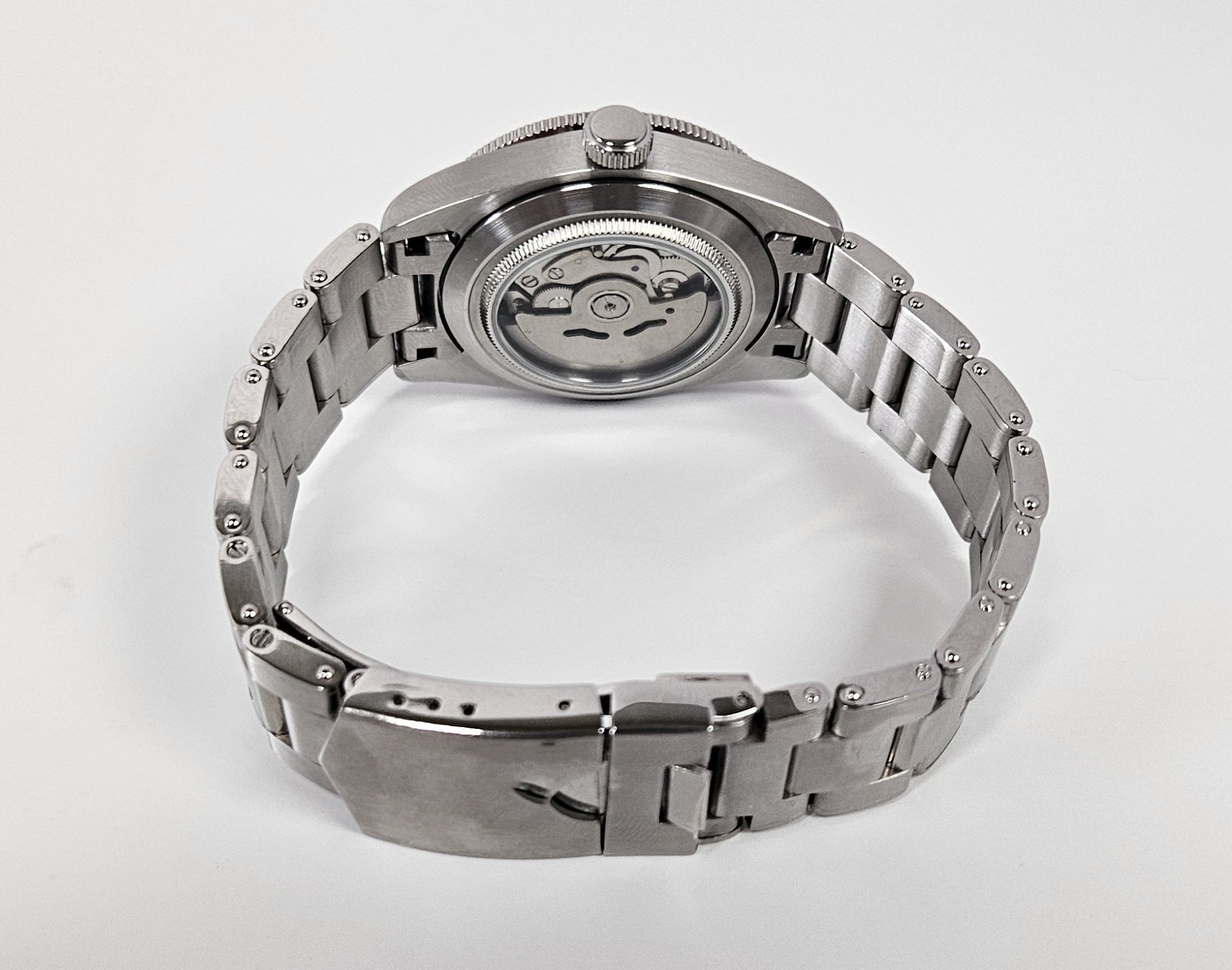 Silver watch with a metallic band on a white background