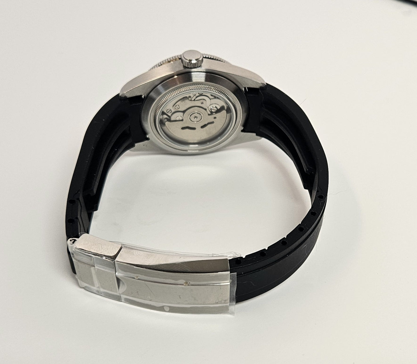 Watch with black strap and silver case on a white background