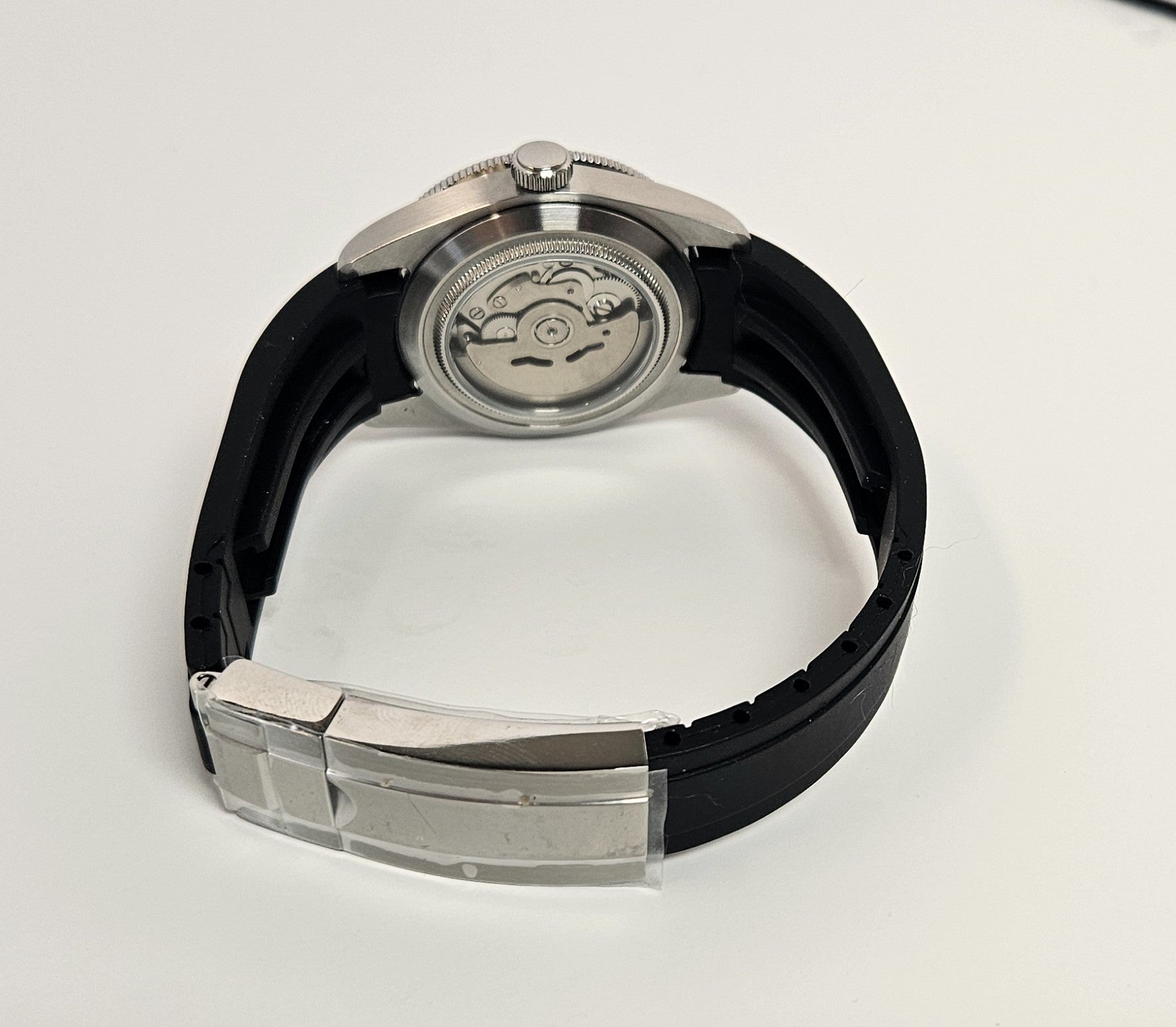 Watch with black strap and silver case on a white background