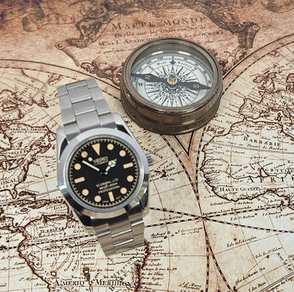 Vintage watch and compass on an old world map