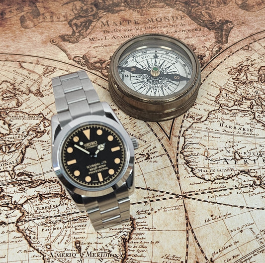 Vintage watch and compass on an old world map