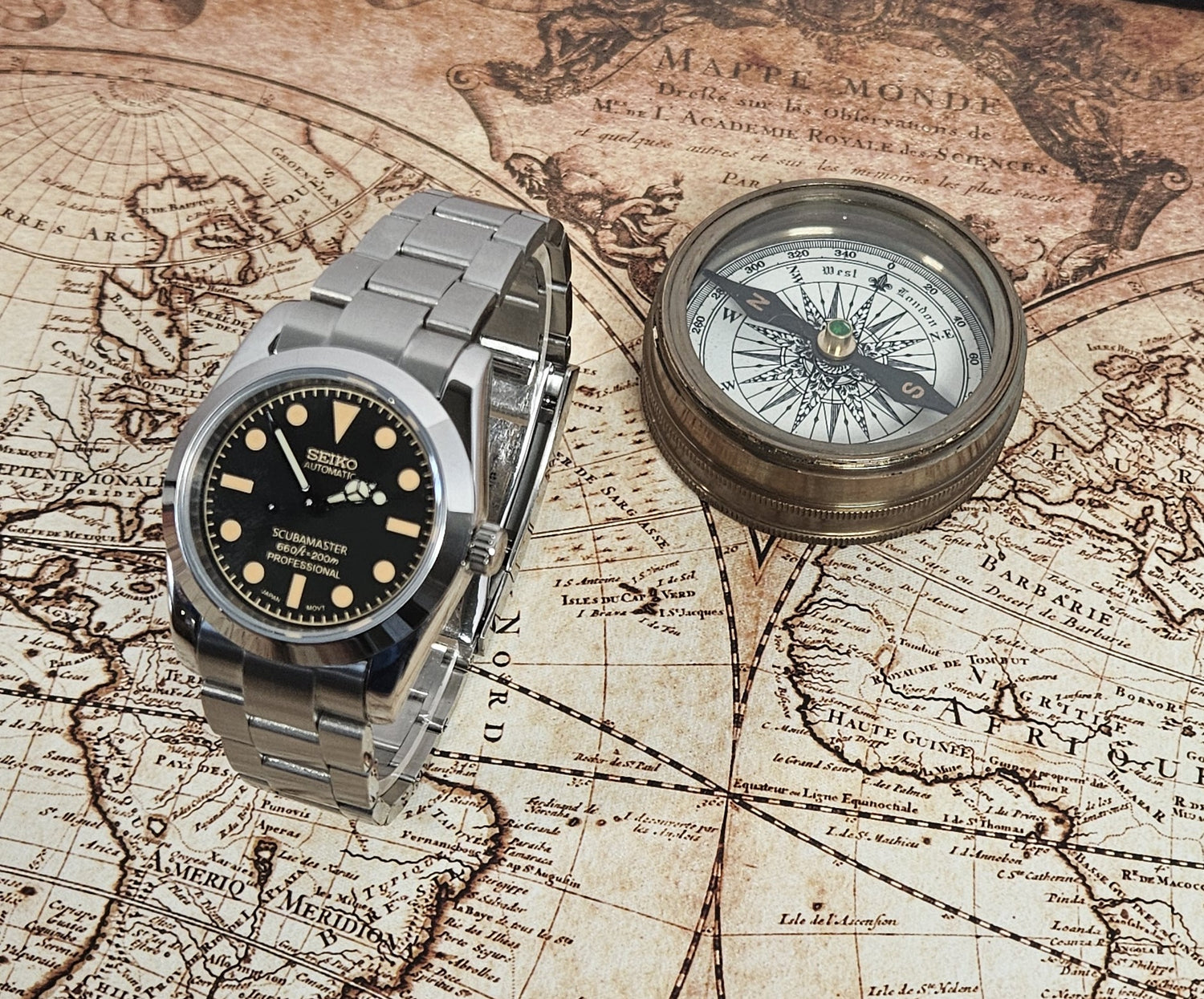 Vintage watch and compass on an old map