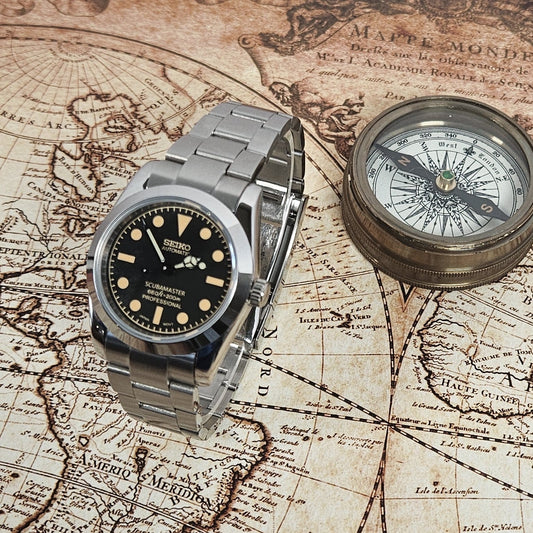 Vintage watch and compass on an old map