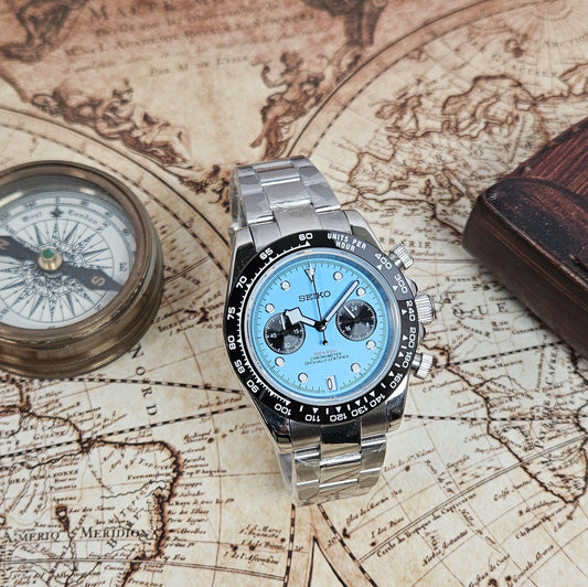 Silver watch with blue face on an old map